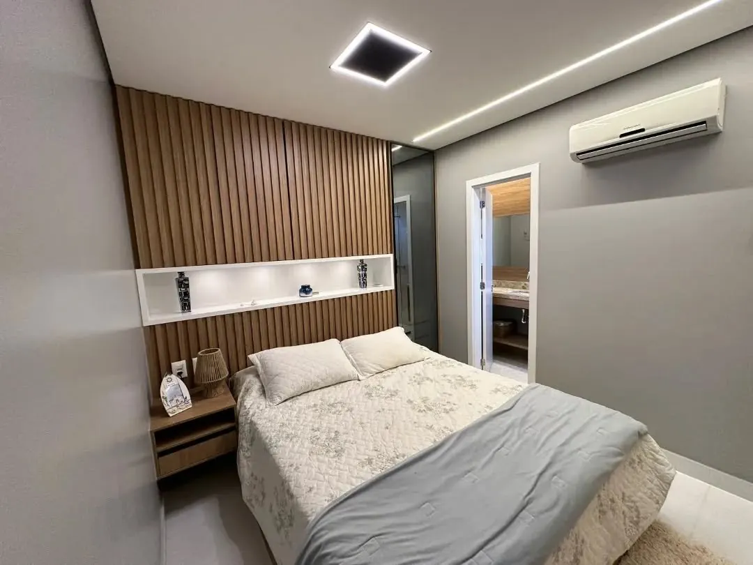 Quarto de casal com painel ripado em madeira, nicho iluminado e criado-mudo suspenso