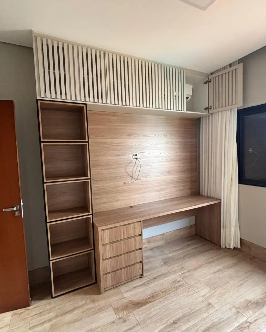 Quarto com bancada de estudo, gaveteiro, painel e nichos em madeira e armário aéreo ripado